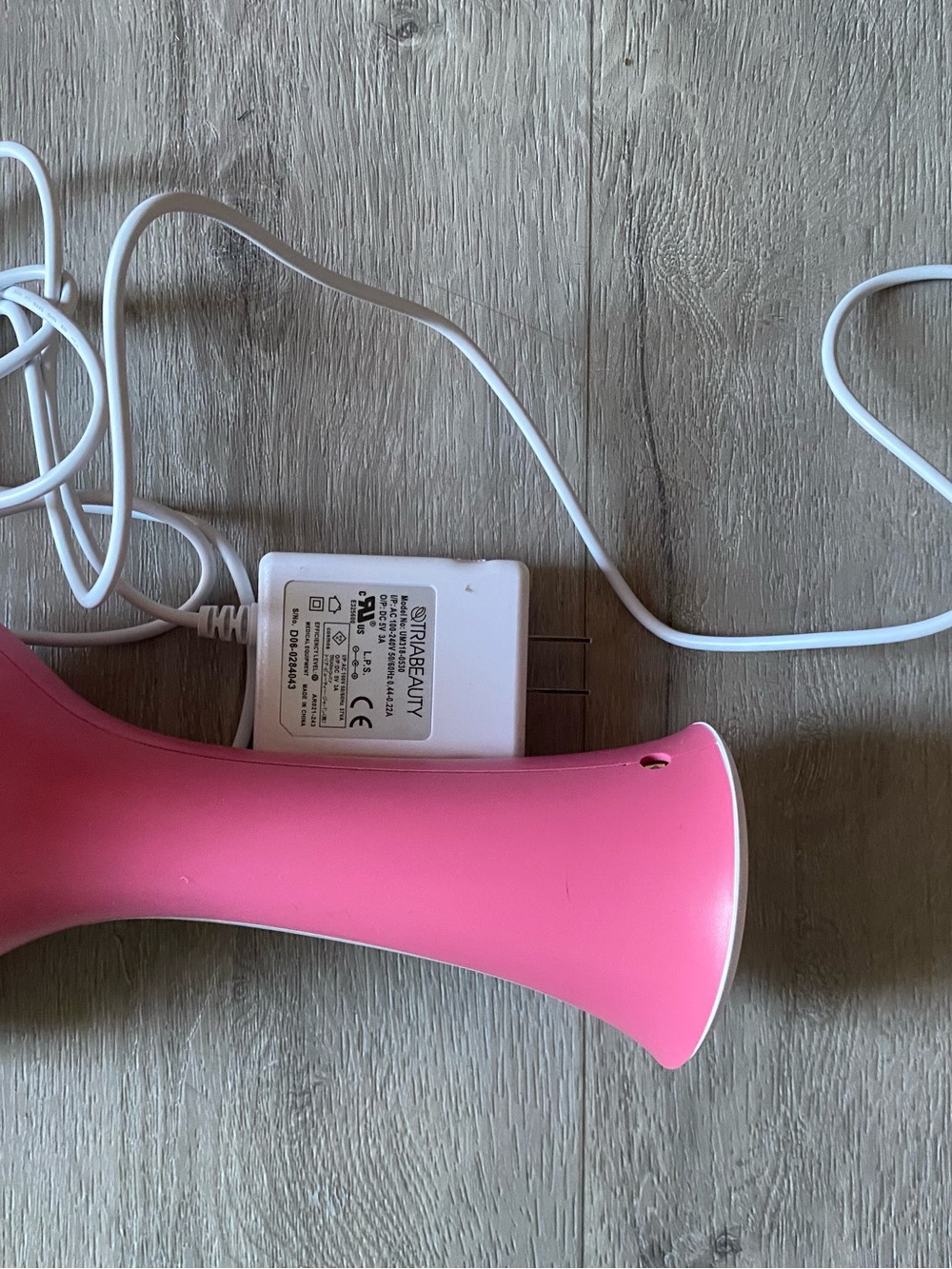 TRIA Beauty Pink Handheld Device with White Charger Adapter